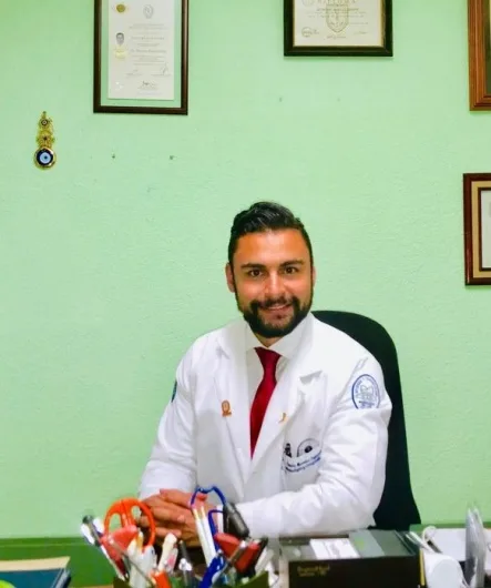 Dr Octavio Rosales à son bureau, devant ses diplômes